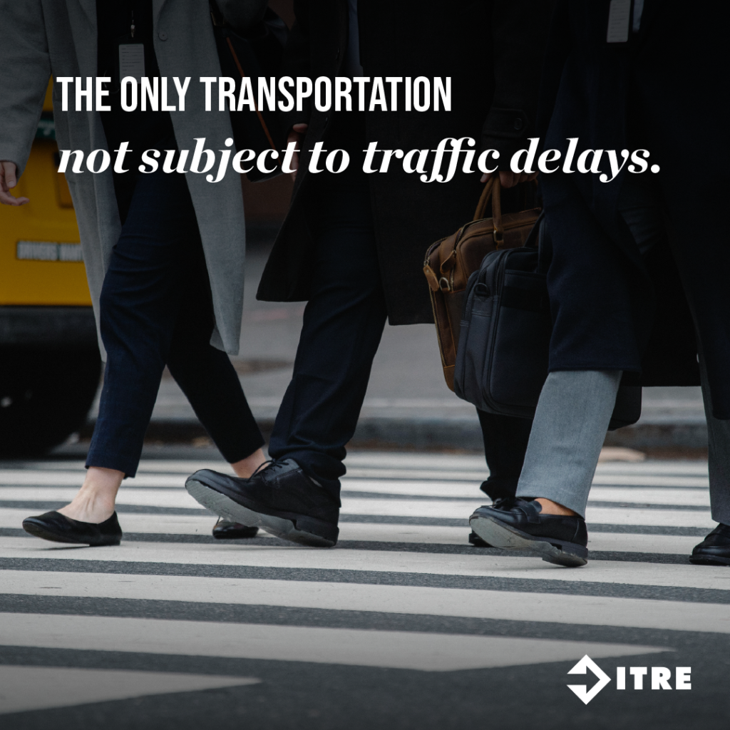 Image depicts a close up of people walking across a crosswalk. Text reads “The only transportation not subject to traffic delays.”