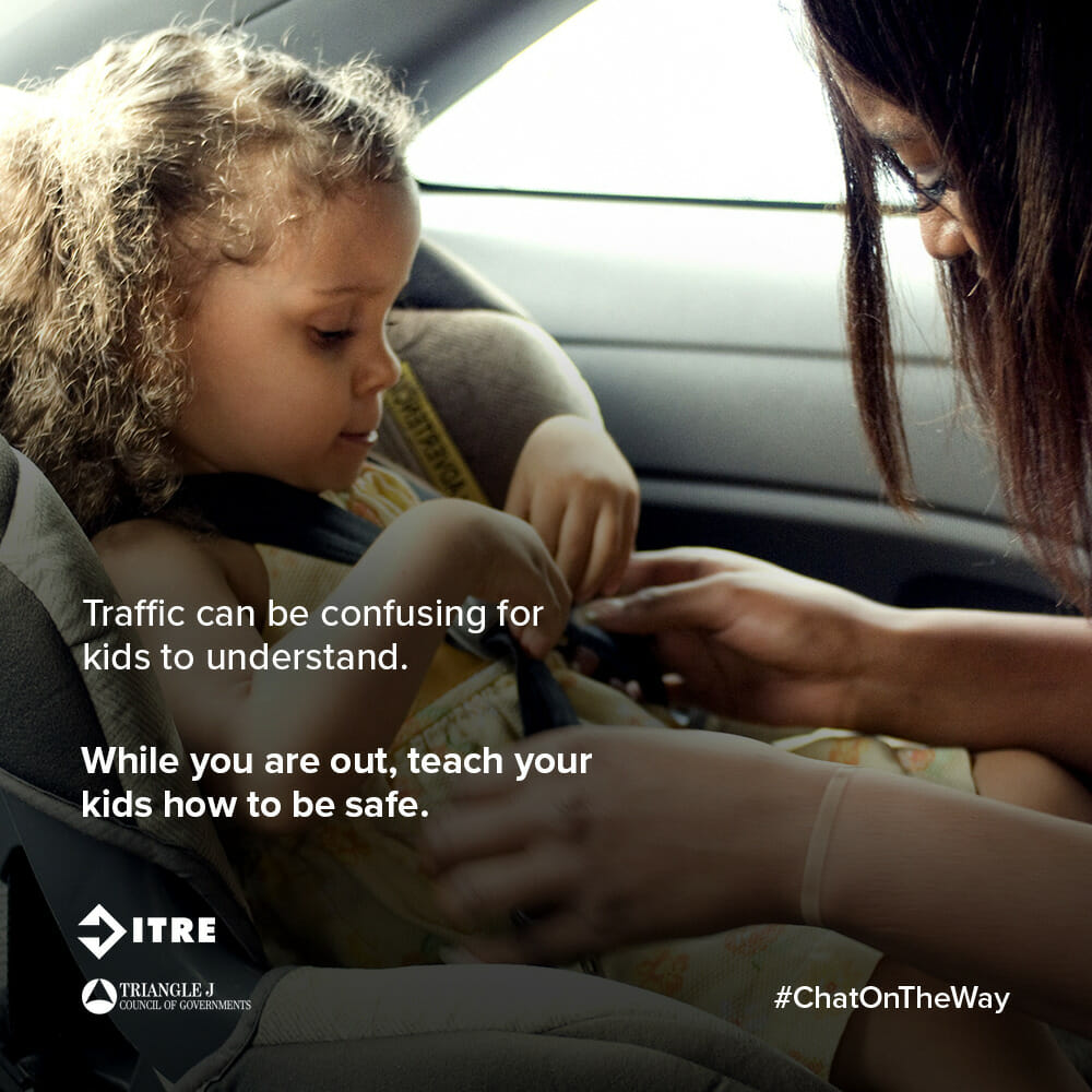 Image depicts a mother buckling her daughter into her car seat. Text reads “Traffic can be confusing for kids to understand. While you are out, teach your kids how to be safe.”